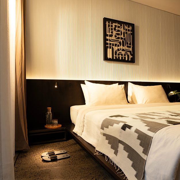 Modern minimalist deluxe hotel room with monochromatic decor and designer lighting at Titik Dua