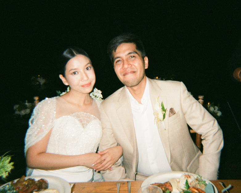 Close-up portrait of a newlywed couple sitting at their wedding dinner table in Bali